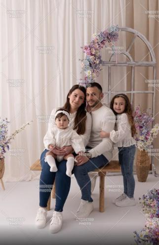 Eine Familie sitzt mit einem Baby auf einer Bank. in der Unterkunft Oyster 2 Beachfront bliss in Qbajjar