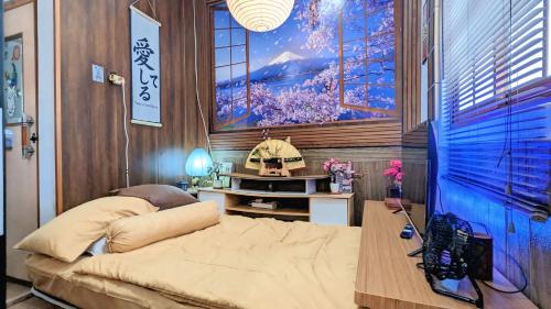 a bedroom with a bed and a painting on the wall at Hanki Guest House syariah in Gadok 1
