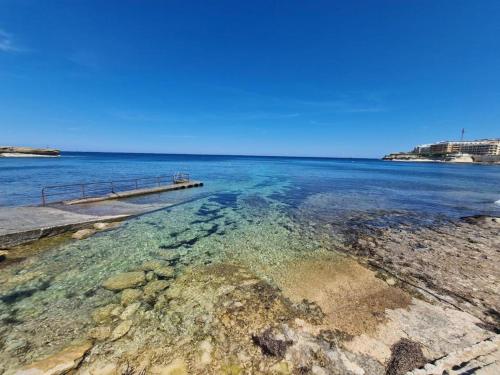 ein Gewässer mit einem Pier und dem Meer in der Unterkunft Oyster 2 Beachfront bliss in Qbajjar