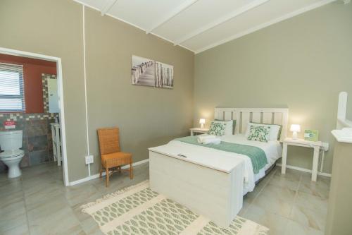 a white bedroom with a bed and a bathroom at Accommodation on 3329 - Unit 2 in Gqeberha