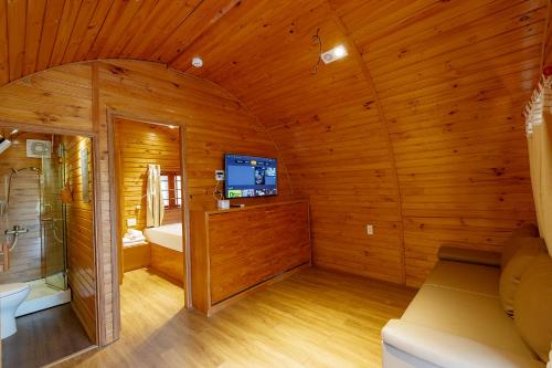 a room with a tv in a wooden cabin at Sim Forest Resort in Phú Quốc