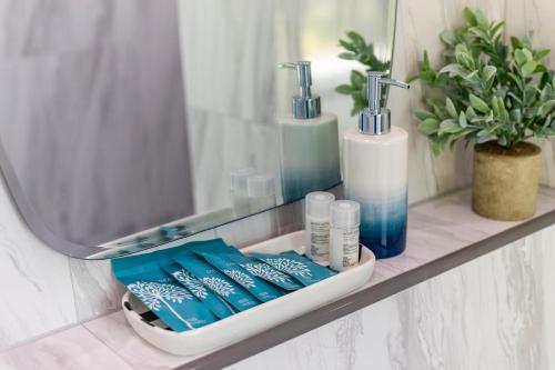 a bathroom shelf with toothbrushes and a mirror at Nanuea Village Ao Nang in Ao Nang Beach