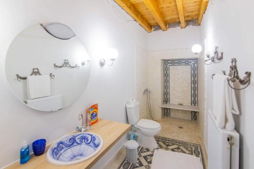 a bathroom with a sink and a toilet and a mirror at Blue Horizon Residence in Mitika