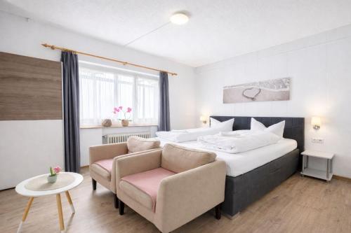 a bedroom with a large bed and a chair at Gästehaus Kühnle in Bad Wildbad