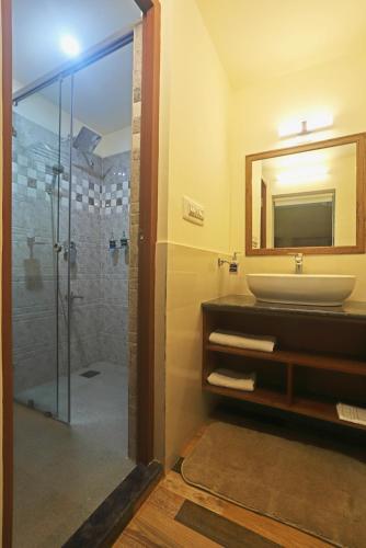 a bathroom with a sink and a mirror at Coffee Courtyard - Boutique Estate Retreat, Coorg in Kurchi