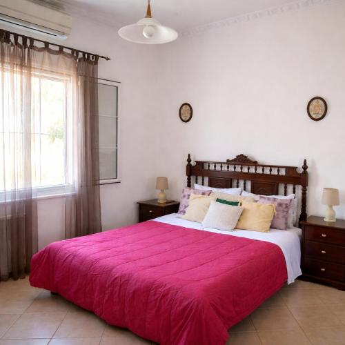 a bedroom with a large bed with a pink blanket at Aegina House in Egina