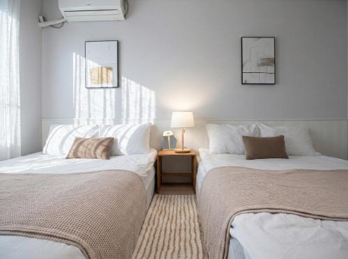 two beds sitting next to each other in a room at Seoul 3R,4B,2BA,All rooms AC, 지하철도보5분, 동대문15분, 명동25분, 이태원,성수,서울역 30분 in Seoul