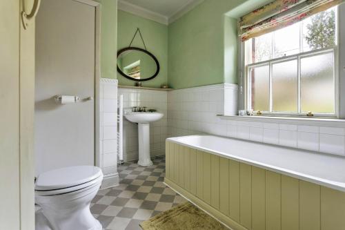 a bathroom with a tub and a toilet and a sink at Finest Retreats - Bourne Edge in Morland