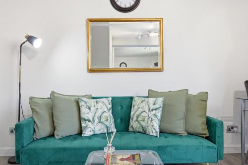 a green couch in a living room with a mirror at Luxury Kensington Apt - Walk to Harrods in London