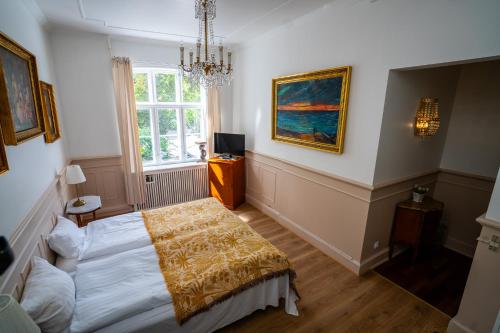 a bedroom with a bed and a painting on the wall at Hotel Allegade 10 in Copenhagen