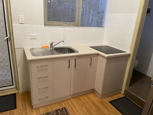 a small kitchen with a sink and a window at North Adelaide Studio in North Adelaide