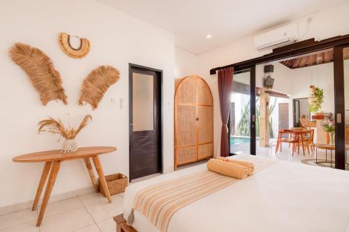 a bedroom with a large bed and a table at Cozy villa 2bdr in Seminyak , pool,800m beach in Seminyak