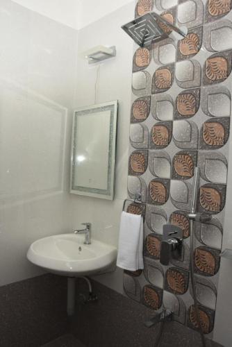 a bathroom with a sink and a mirror at Sea Shore In in Port Blair