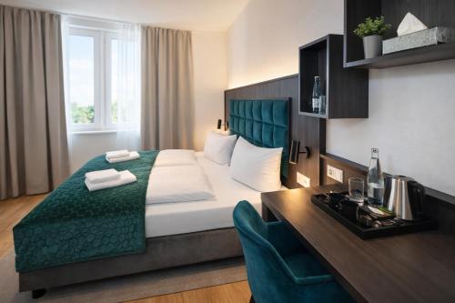 a hotel room with a bed and a desk at Hotel Hamburg Nord in Norderstedt