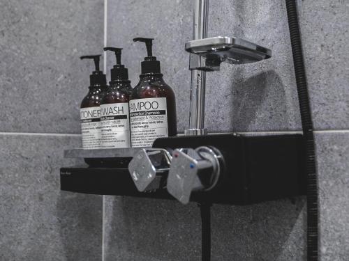 a group of three shampoo bottles sitting on a holder in a shower at Seoul 3R,4B,2BA,All rooms AC, 지하철도보5분, 동대문15분, 명동25분, 이태원,성수,서울역 30분 in Seoul