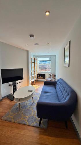 a living room with a blue couch and a table at Ibis House by Viridian Apartments in Richmond
