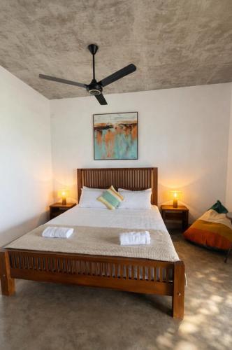 a bedroom with a bed with a ceiling fan at Stonewater Beach Villa, Negombo in Mahawatta