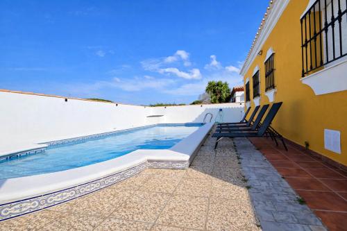 a swimming pool on the side of a building at Casa oasis de chiclana in Novo Sancti Petri