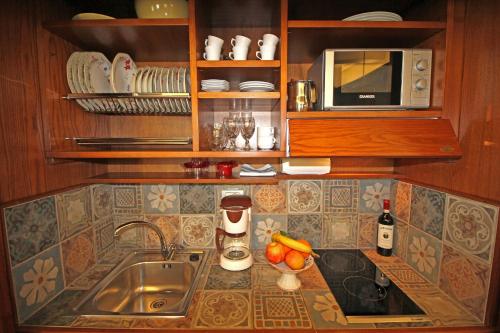 a kitchen counter with a sink and a microwave at La Casa sulla Piazza in Cortona