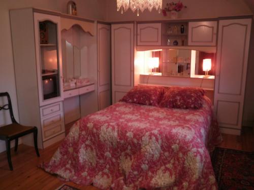 a bedroom with a bed and a chandelier at Le clos des mûriers in Hautot-sur-Mer