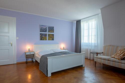 a white bedroom with a bed and a couch at B&B Zoo Caffè & Ristorante in Zurich
