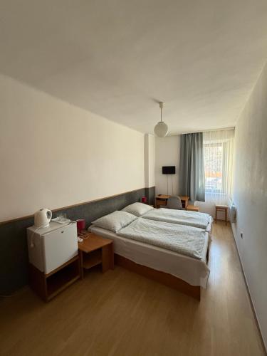 a bedroom with a bed and a table in it at Penzion Vis a Vis in Třebíč