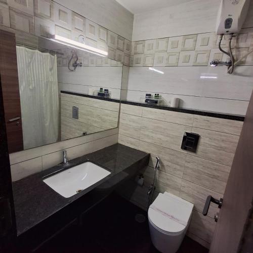 a bathroom with a sink and a toilet at Hotel SVM Grand Medipally in Upal
