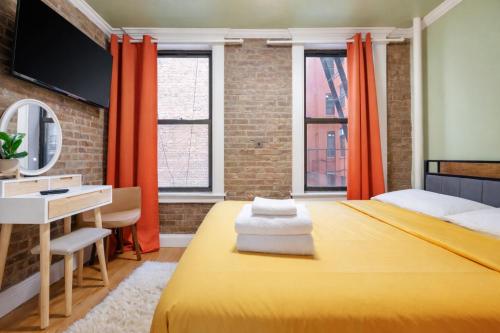 a bedroom with a yellow bed and a desk at 2 Bedroom Home Unit In Lower Manhattan in New York
