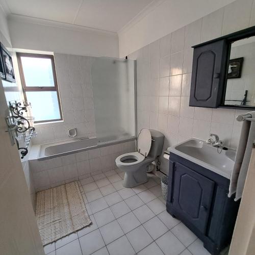 a bathroom with a toilet and a tub and a sink at Hibberdene Beachfront Self-Catering 9 Catalina Bay in Hibberdene