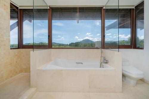 a bathroom with a tub and a toilet and a window at 4BR Penthouse Royal Marina 6B Private Rooftop Pool with 360 View in Phuket