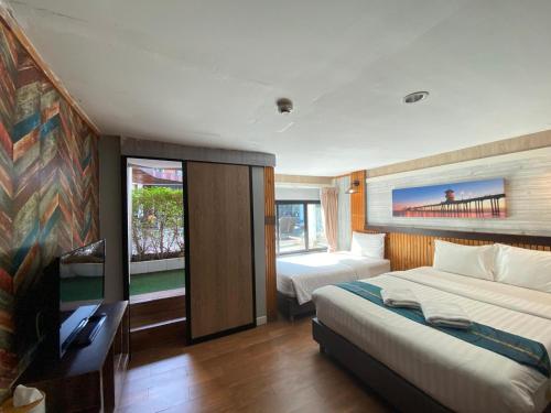 a bedroom with two beds and a tv in it at Tamnan Resort Pattaya in Ban Nong Chaeng