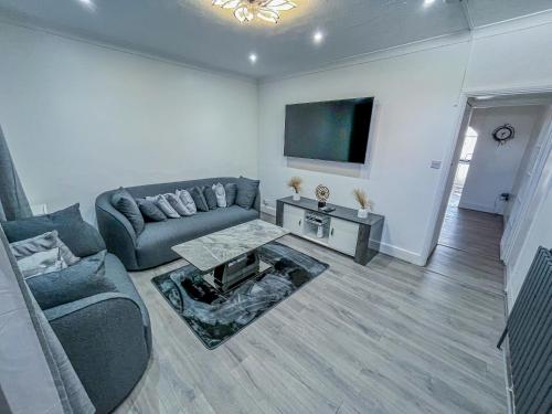 a living room with a couch and a tv at Eugino Properties in Grays Thurrock