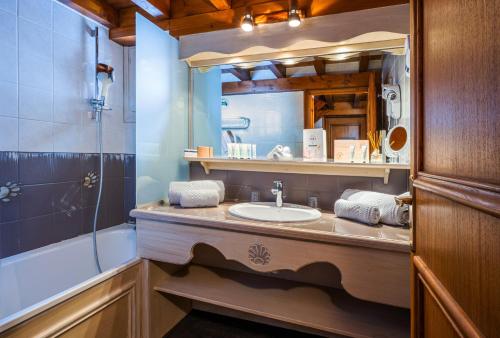 a bathroom with a sink and a shower and a mirror at Hôtel les Campanules by Les Etincelles in Tignes