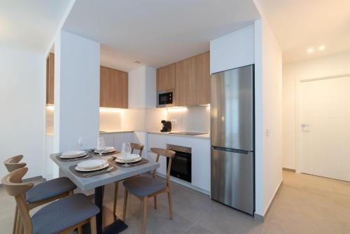 a kitchen with a table and chairs and a refrigerator at Ereza Suites in Arrecife