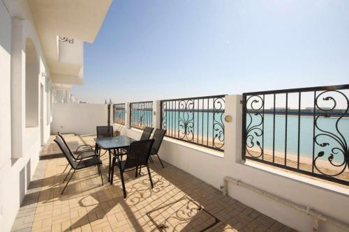 a balcony with a table and chairs on it at Silk Valley – Beachfront 3BR near Al Hamriyah in Sharjah