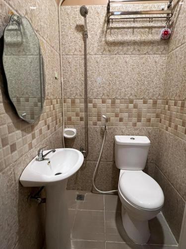 a bathroom with a toilet and a sink at Nielo's Apartment Door 5 in Dapitan