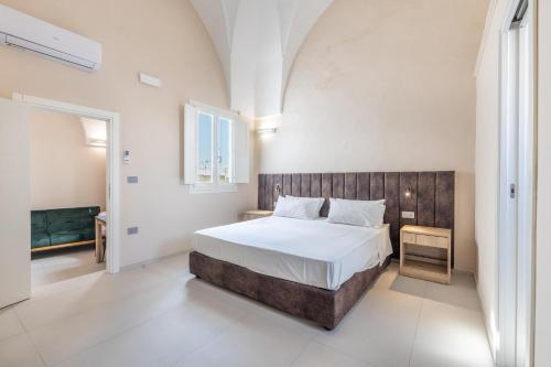 a bedroom with a large bed with a wooden headboard at Dimora Suite Platino in Gallipoli