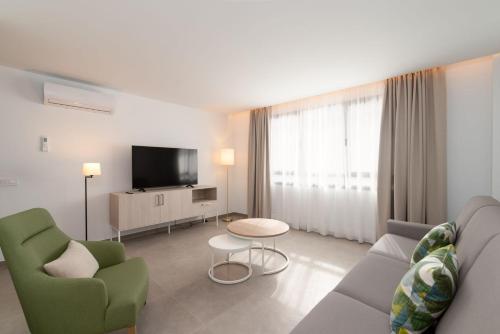 a living room with a couch and a tv at Ereza Suites in Arrecife