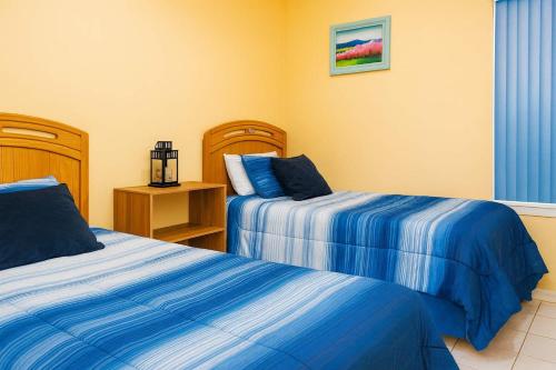 a bedroom with two beds with blue and white sheets at BBQ ok Ground Floor Duplex 1-2 block to Beach in South Padre Island