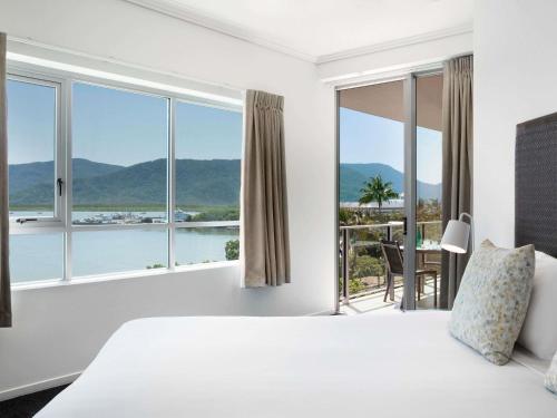 a bedroom with a bed and a view of the ocean at Mantra Trilogy in Cairns