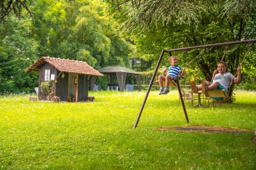 a man and a boy sitting on a swing at Residence CATULLO in Bezzecca