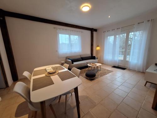 a living room with a table and a couch at Escapade au Lac in Corancy