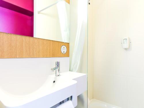 een badkamer met een wastafel en een spiegel bij B&B HOTEL Toulouse Basso Cambo in Toulouse