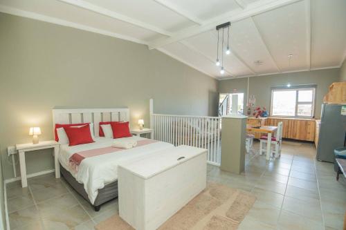 a bedroom with a large bed with red pillows at Accommodation on 3329 - Unit 3 in Gqeberha