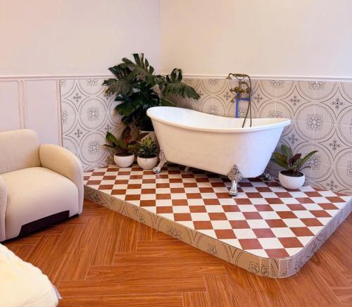 a bathroom with a bath tub on a checkered floor at GÓC MƠ home in Da Thanh