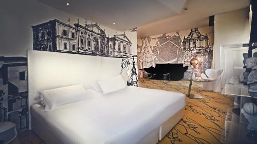 una camera da letto con un letto bianco e un quadro sulla parete di Hotel Ripa Roma a Roma
