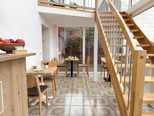 a room with a staircase and tables and chairs at Heilotel in Heilbad Heiligenstadt