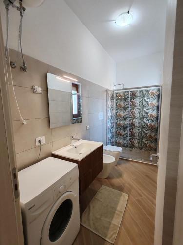 a bathroom with a washing machine and a sink at Appartamento Serenity in Marina di Ascea