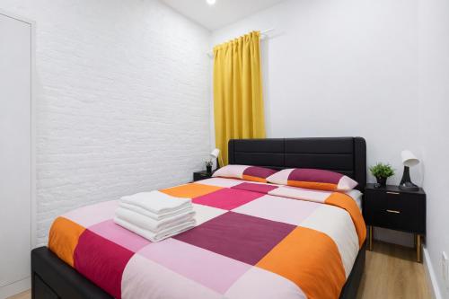 a bedroom with a bed with a colorful blanket at 2 Bedroom Modern Unit in Central Manhattan in New York