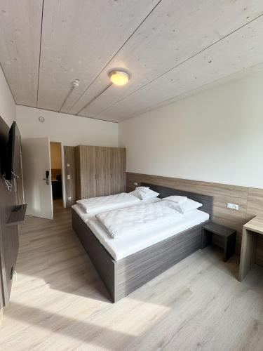 a bedroom with a large bed and a television at A2 Hotel Memmingen - SELF-CHECK-IN in Memmingen